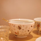 Bowl redondo de porcelana branca da coleção Pinha, decorado com uma estampa festiva de pinhas, folhagens e elementos natalinos em tons de verde, marrom e vermelho. A peça possui tamanho de 14 cm de largura e 7 cm de altura, com design autoral Lolahome desenvolvido no Brasil, apresentando um acabamento refinado e temático. Como deve ser usado: ideal para compor uma mesa posta natalina chic e acolhedora, sendo perfeito para servir petiscos, sobremesas, caldos ou pequenas porções com o charme das festas