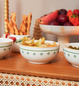 Bowl redondo de porcelana branca da coleção Zahidi, apresentando estampa exclusiva com detalhes em verde e dourado. A peça possui tamanho de 12 cm de diâmetro por 8 cm de altura, com design autoral Lolahome produzido no Brasil, garantindo um acabamento chic e atemporal para a mesa posta.