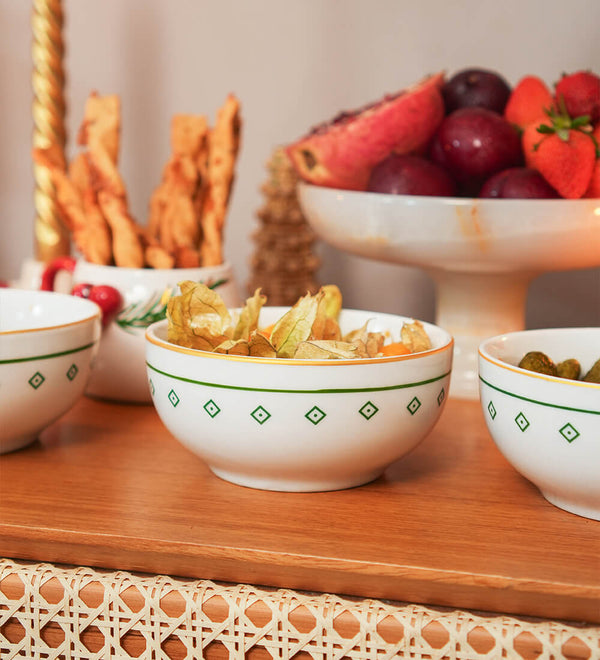 Bowl redondo de porcelana branca da coleção Zahidi, apresentando estampa exclusiva com detalhes em verde e dourado. A peça possui tamanho de 12 cm de diâmetro por 8 cm de altura, com design autoral Lolahome produzido no Brasil, garantindo um acabamento chic e atemporal para a mesa posta.