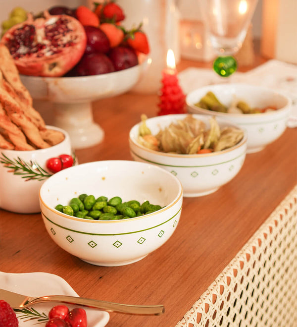 Bowl redondo de porcelana branca da coleção Zahidi, apresentando estampa exclusiva com detalhes em verde e dourado. A peça possui tamanho de 12 cm de diâmetro por 8 cm de altura, com design autoral Lolahome produzido no Brasil, garantindo um acabamento chic e atemporal para a mesa posta.