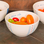 Bowl redondo de cerâmica artesanal branca da coleção La Dolce Vita, apresentando estampa exclusiva com detalhes em tons de marsala e azul. A peça possui tamanho de 13 cm, com acabamento manual e design autoral Lolahome, destacando as variações únicas de cor e forma de um produto produzido de forma artística no Brasil.