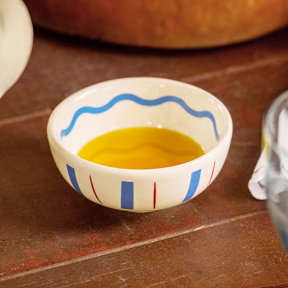 Molheira redonda de cerâmica artesanal branca da coleção La Dolce Vita, com delicados detalhes pintados à mão nas cores marsala e azul. A peça possui design autoral Lolahome com tamanho de 10 x 5 (h) cm, apresentando acabamento rústico e sofisticado com as variações únicas de um produto feito à mão.